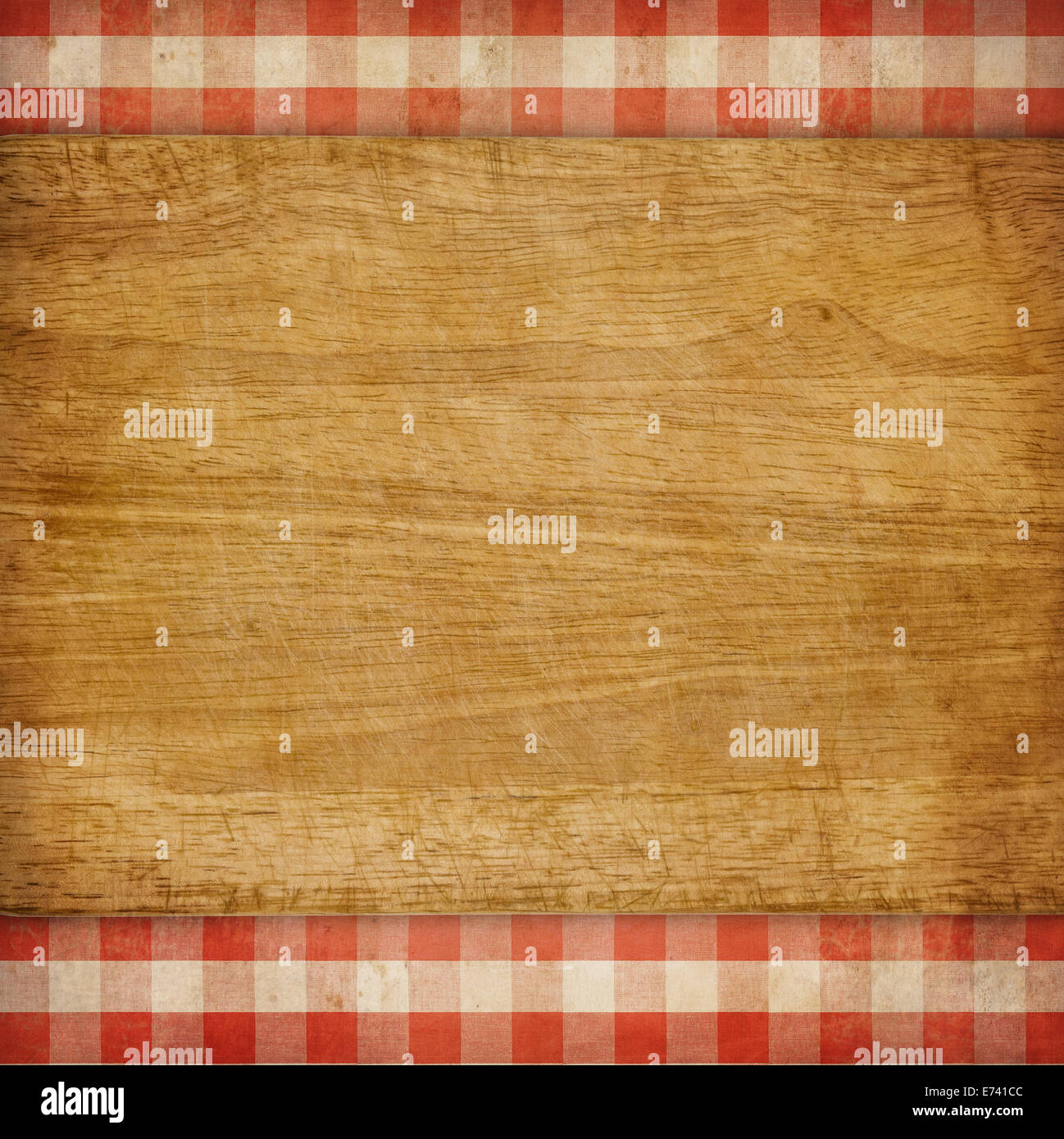 Cutting board over red grunge checked gingham picnic tablecloth background Stock Photo