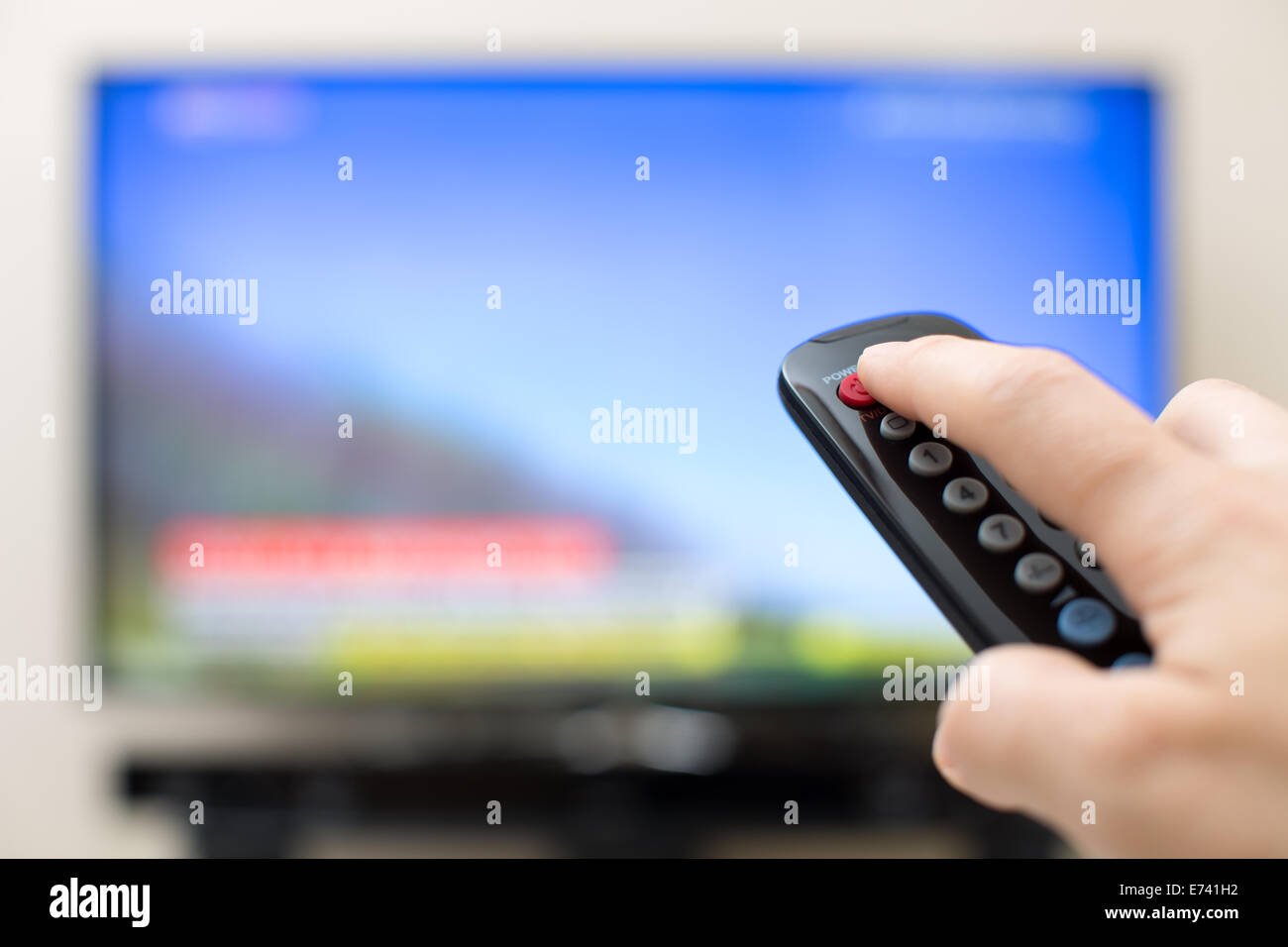 Power button pressing on TV remote control Stock Photo