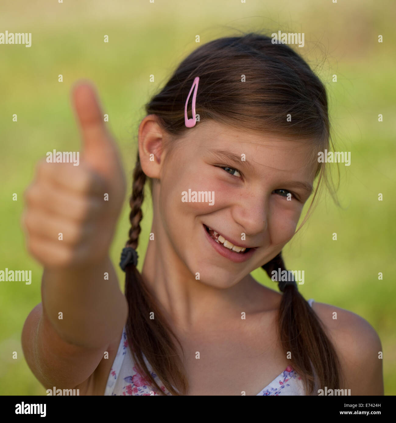 Happy smiling young girl outdoor giving thumbs up Stock Photo - Alamy