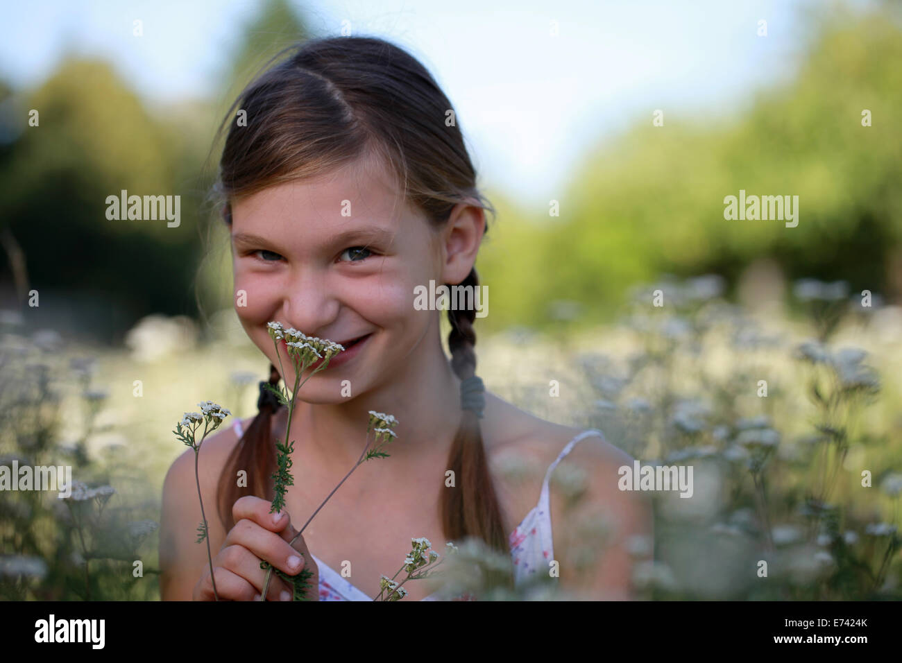 Happy smiling young girl outdoor holding a flower Stock Photo - Alamy