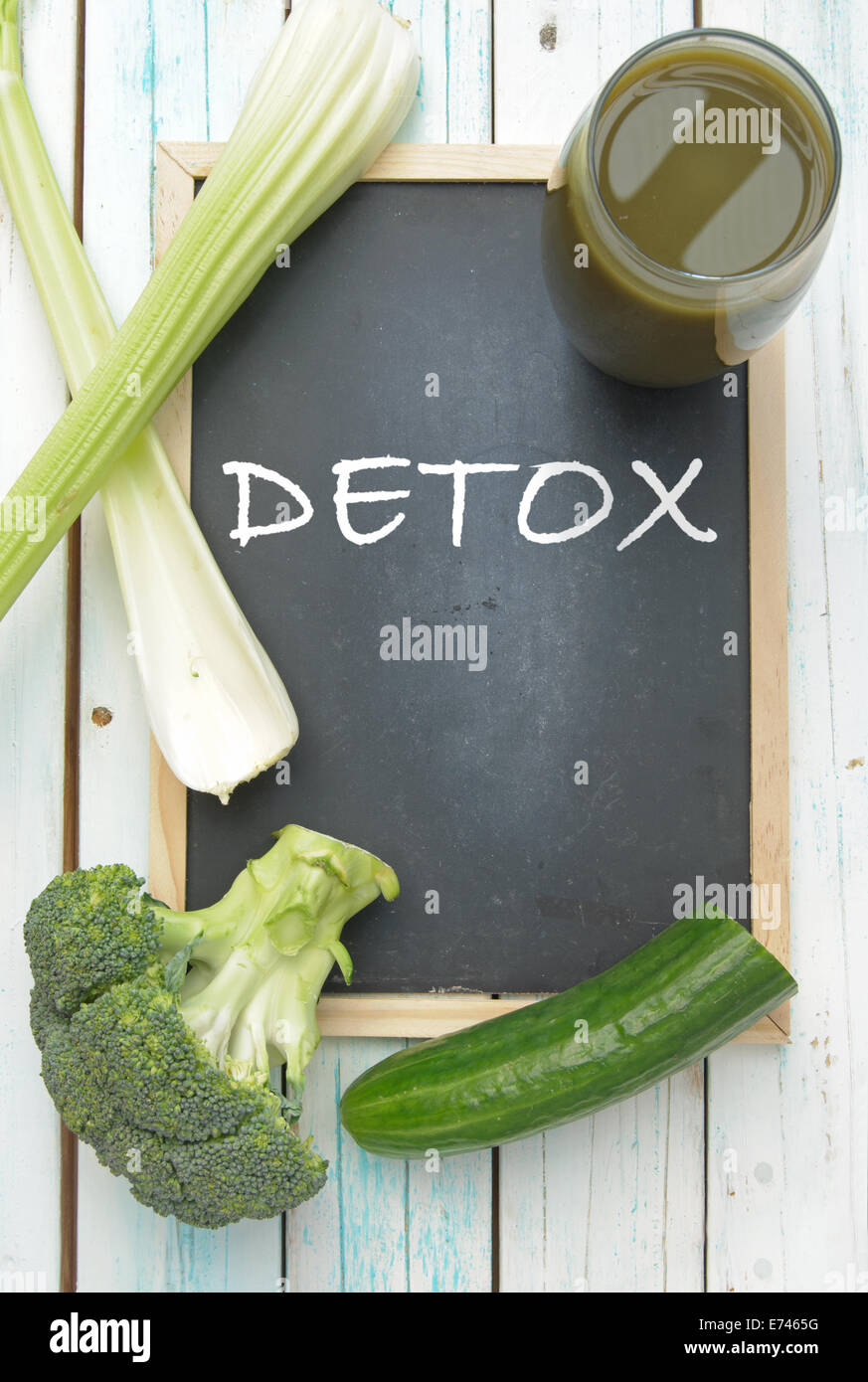 Detox handwritten on a blackboard with a green vegetable smoothie and ingredients Stock Photo