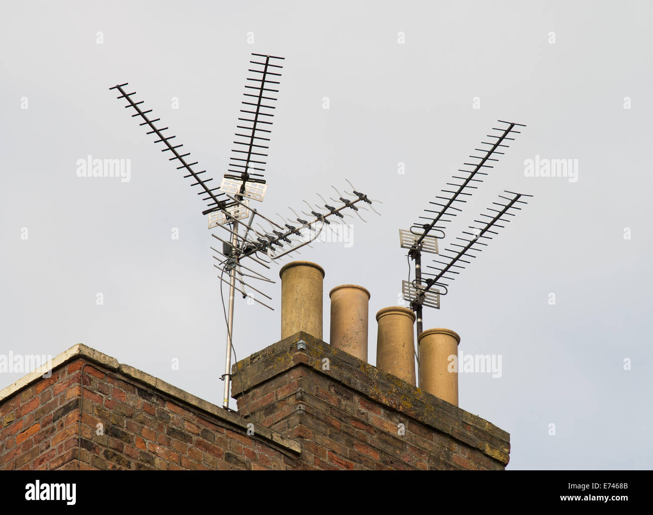 Multiple TV aerials with traditional chimney pots on roof Wisbech, Cambridgeshire, England, UK Stock Photo