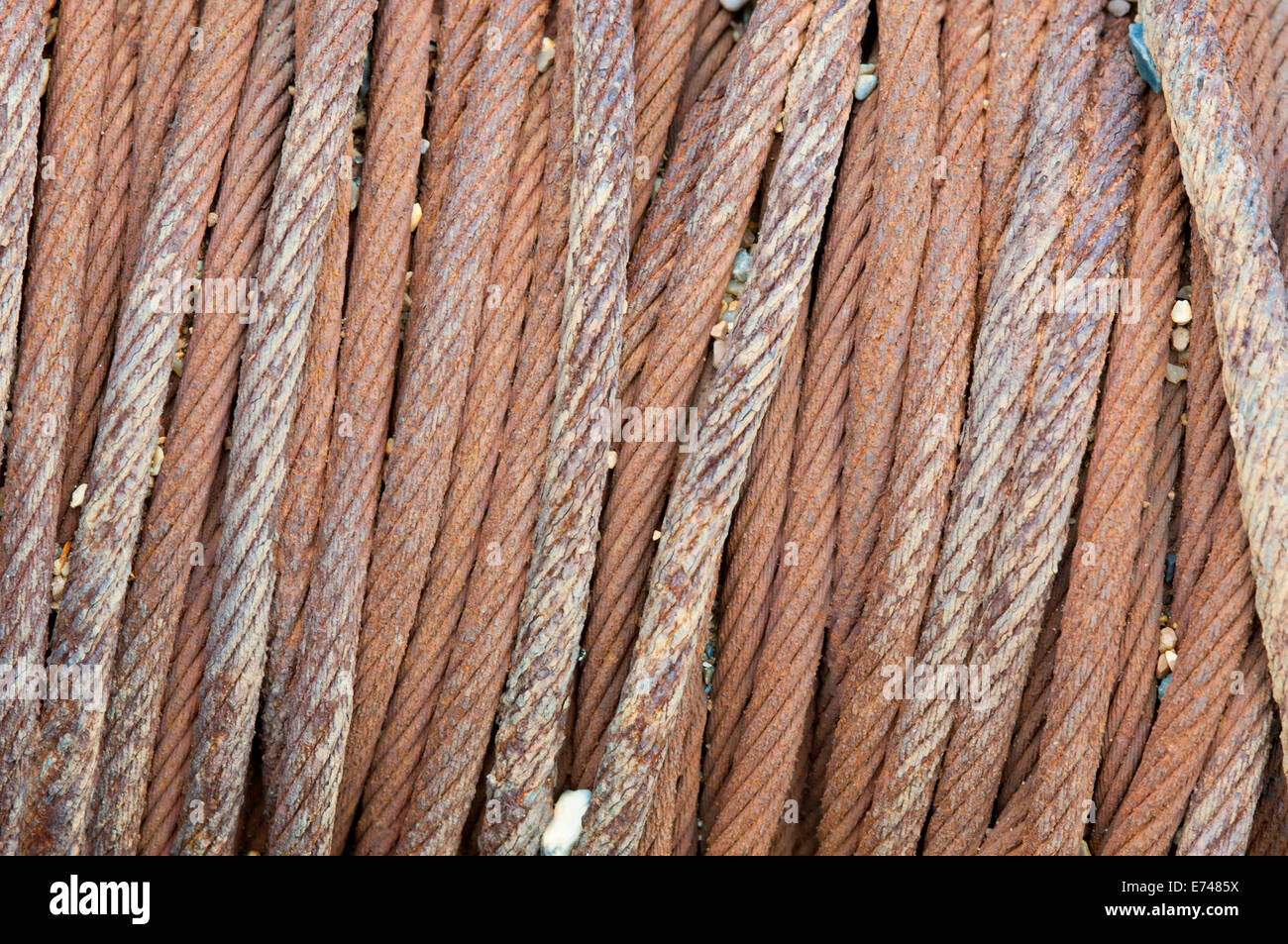Close up of the rusting metal cable of a boat winch on the beach at
