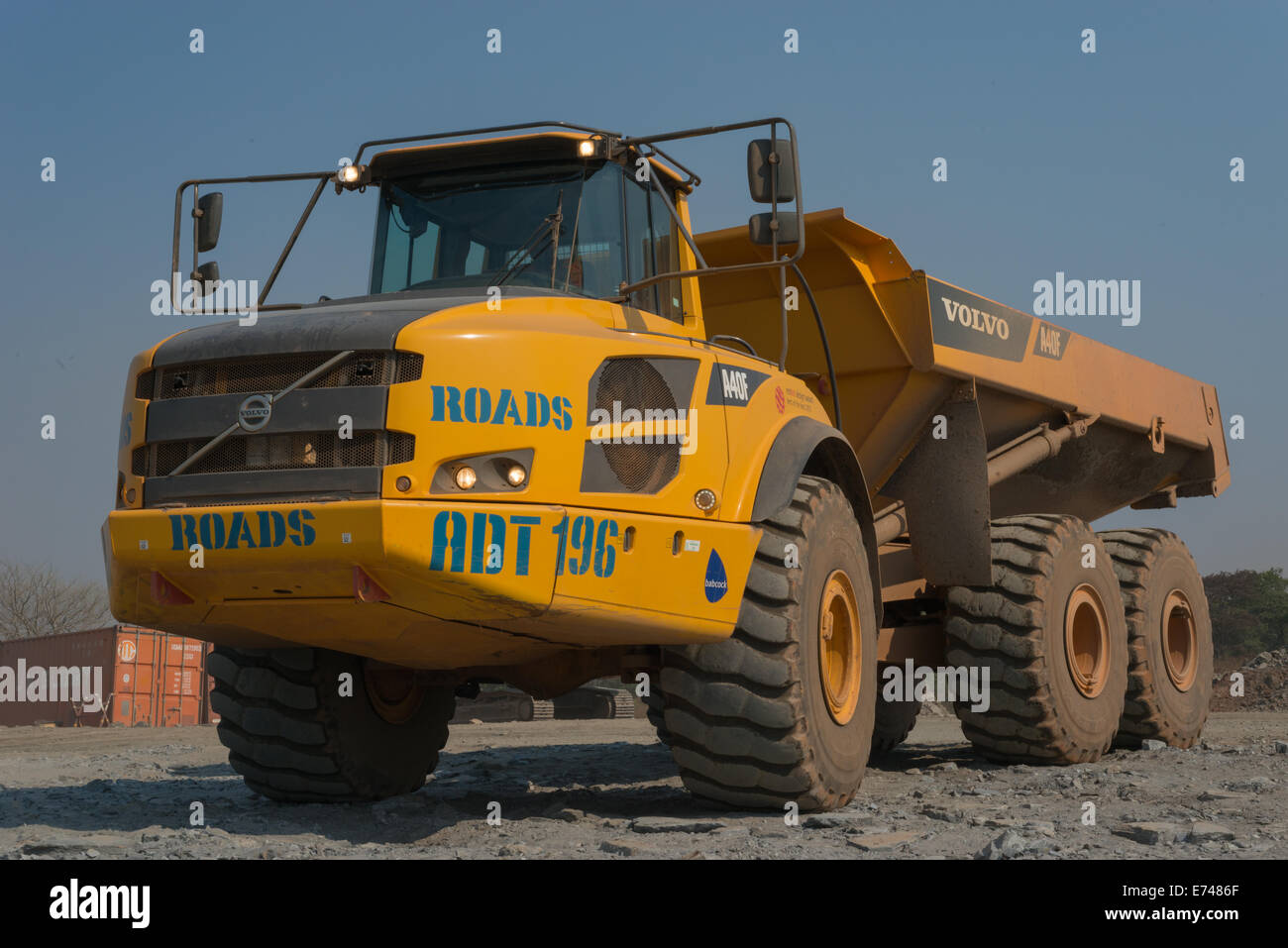 An empty Volvo mining dump truck waits in a queue to be loaded with rock in a large African open cast copper mine. Stock Photo