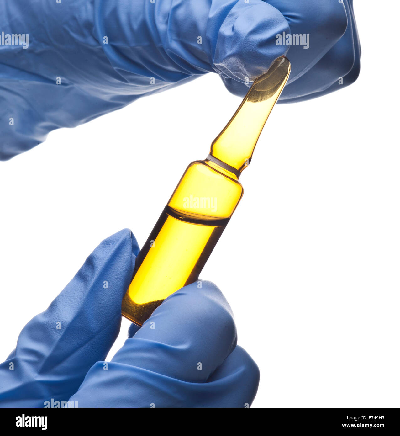 Hands with blue gloves holding an ampoule Stock Photo