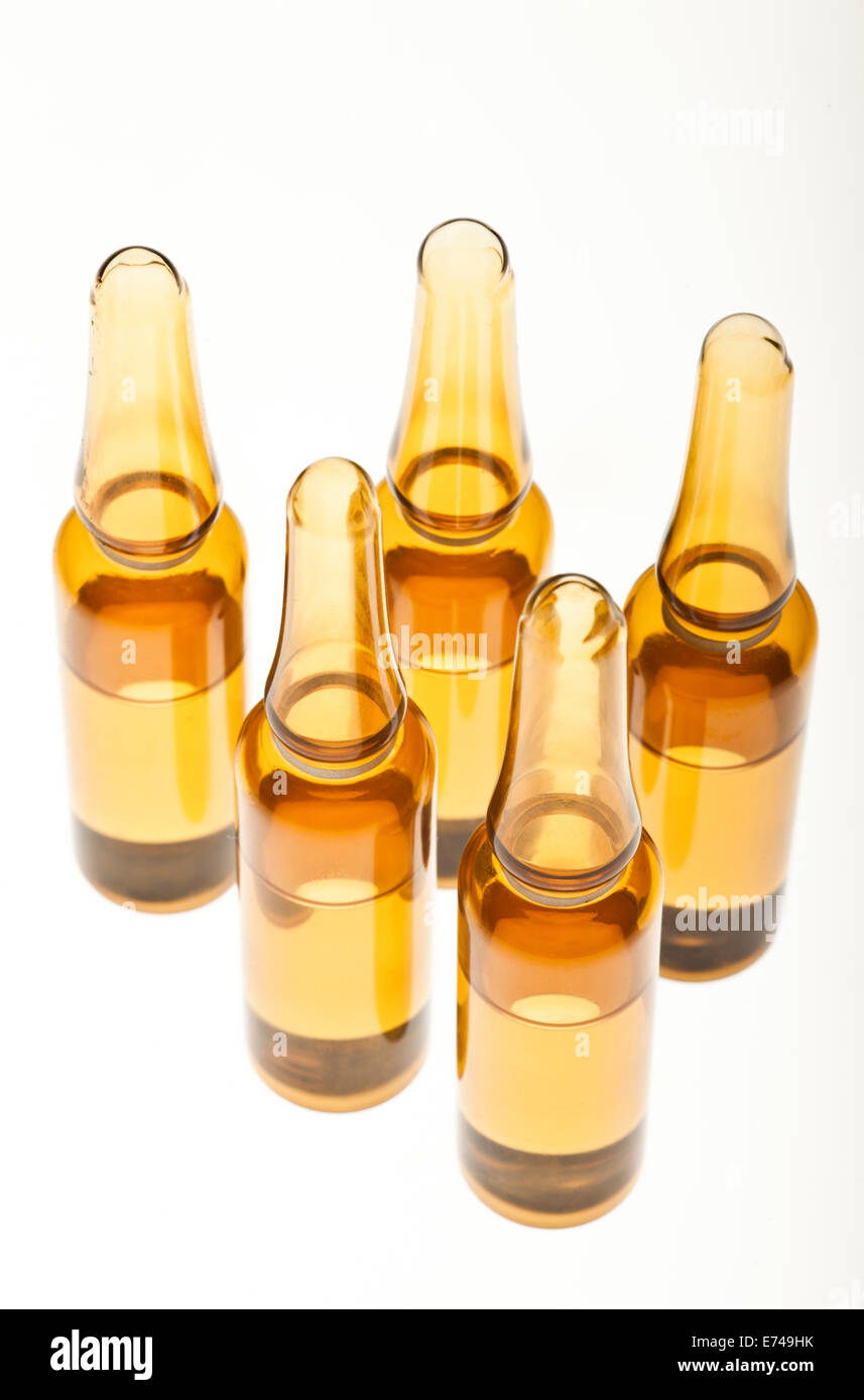 Five brown ampoules on a white background Stock Photo