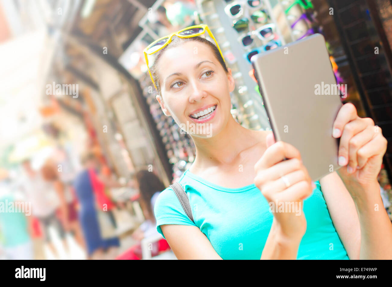 Tourist in the market smiles and holds tablet computer Stock Photo