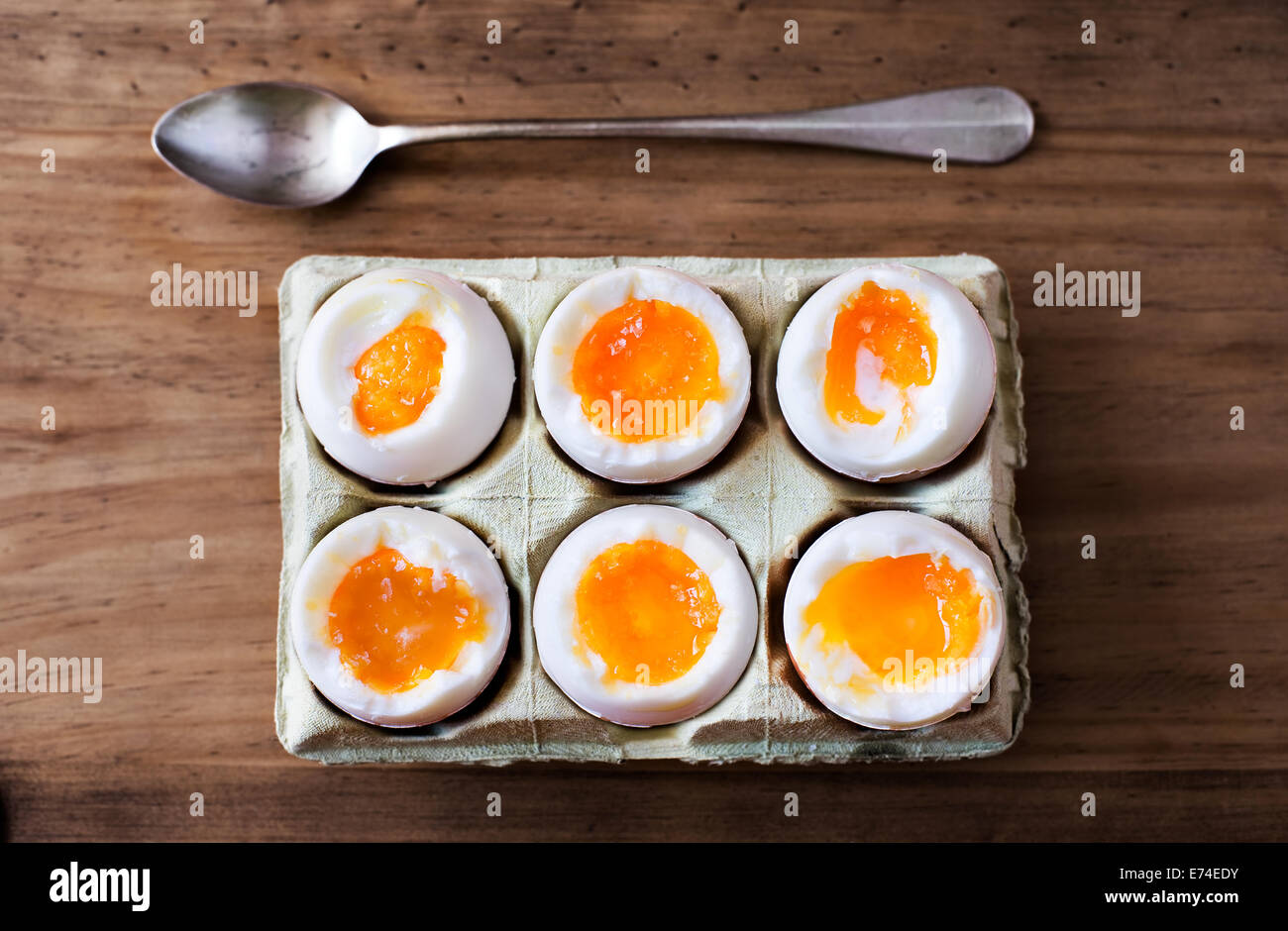 Half a dozen soft boiled eggs in a crate cardboard box. Stock Photo