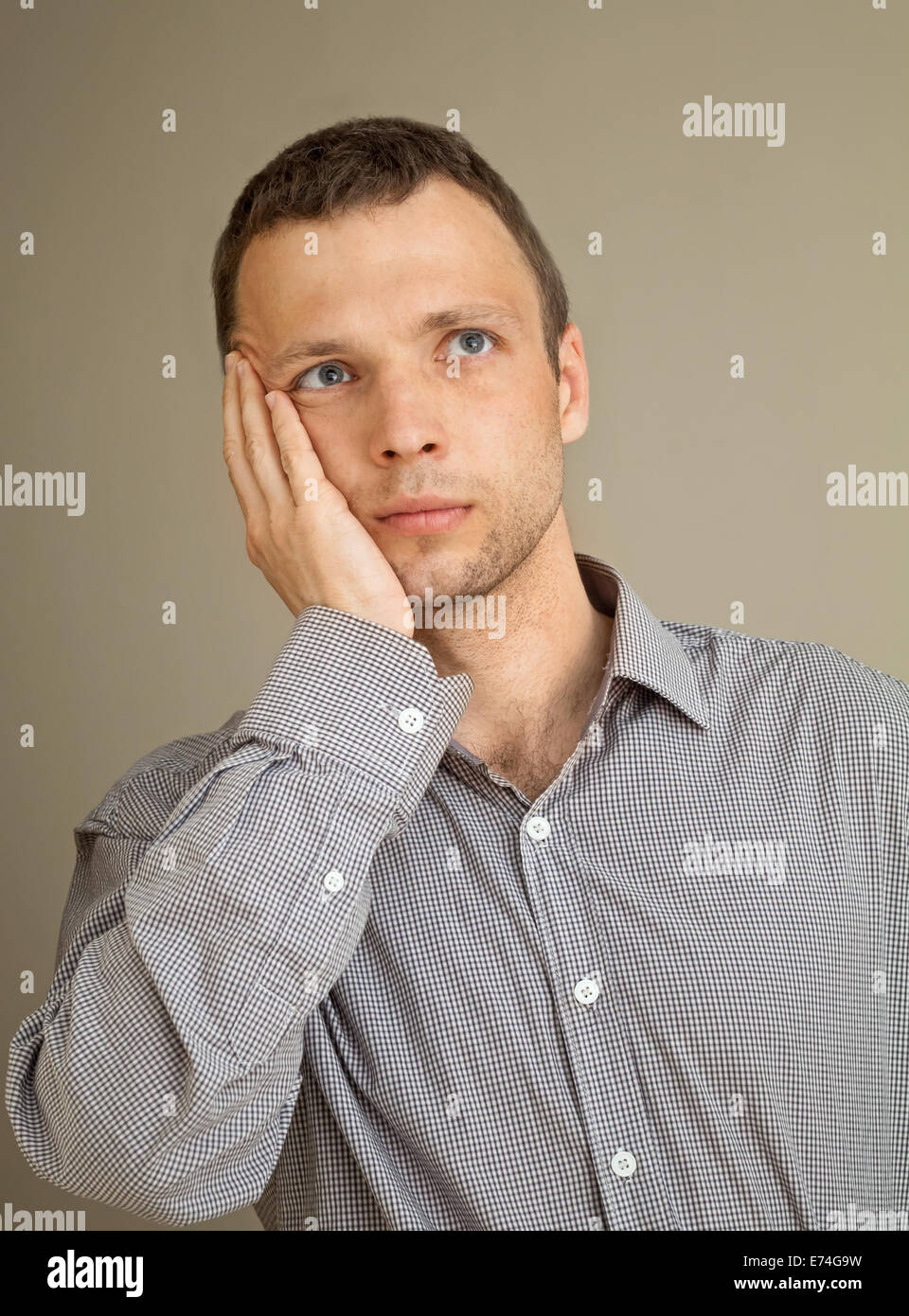Young thinking Caucasian man, casual studio portrait Stock Photo