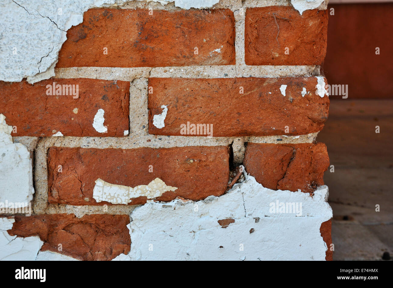 Chipped stucco on brick wall Stock Photo