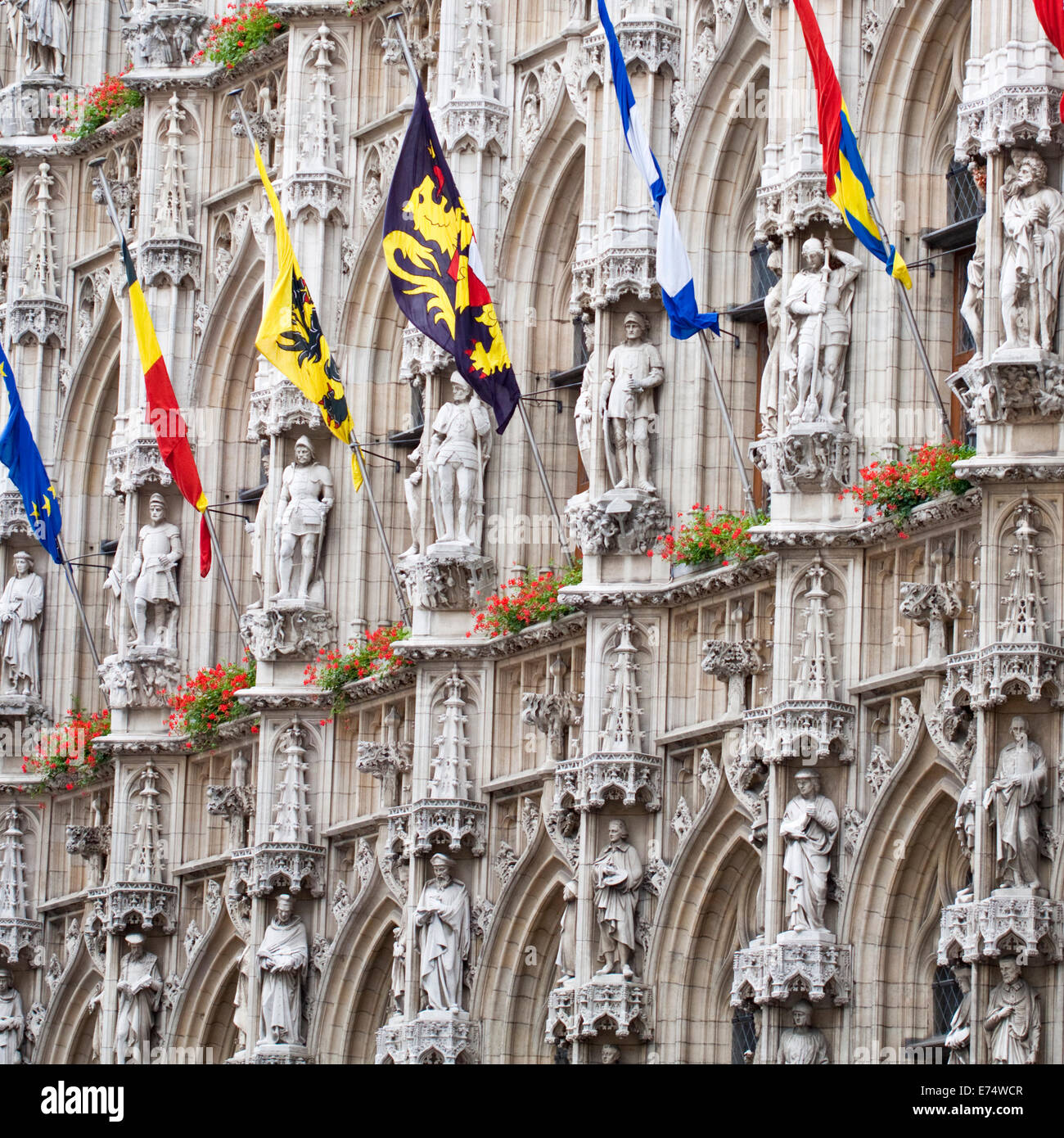 Flags of the world on display against the outside of the impressive 15th century gothic Town Hall in Leuven (Louvain), Belgium Stock Photo