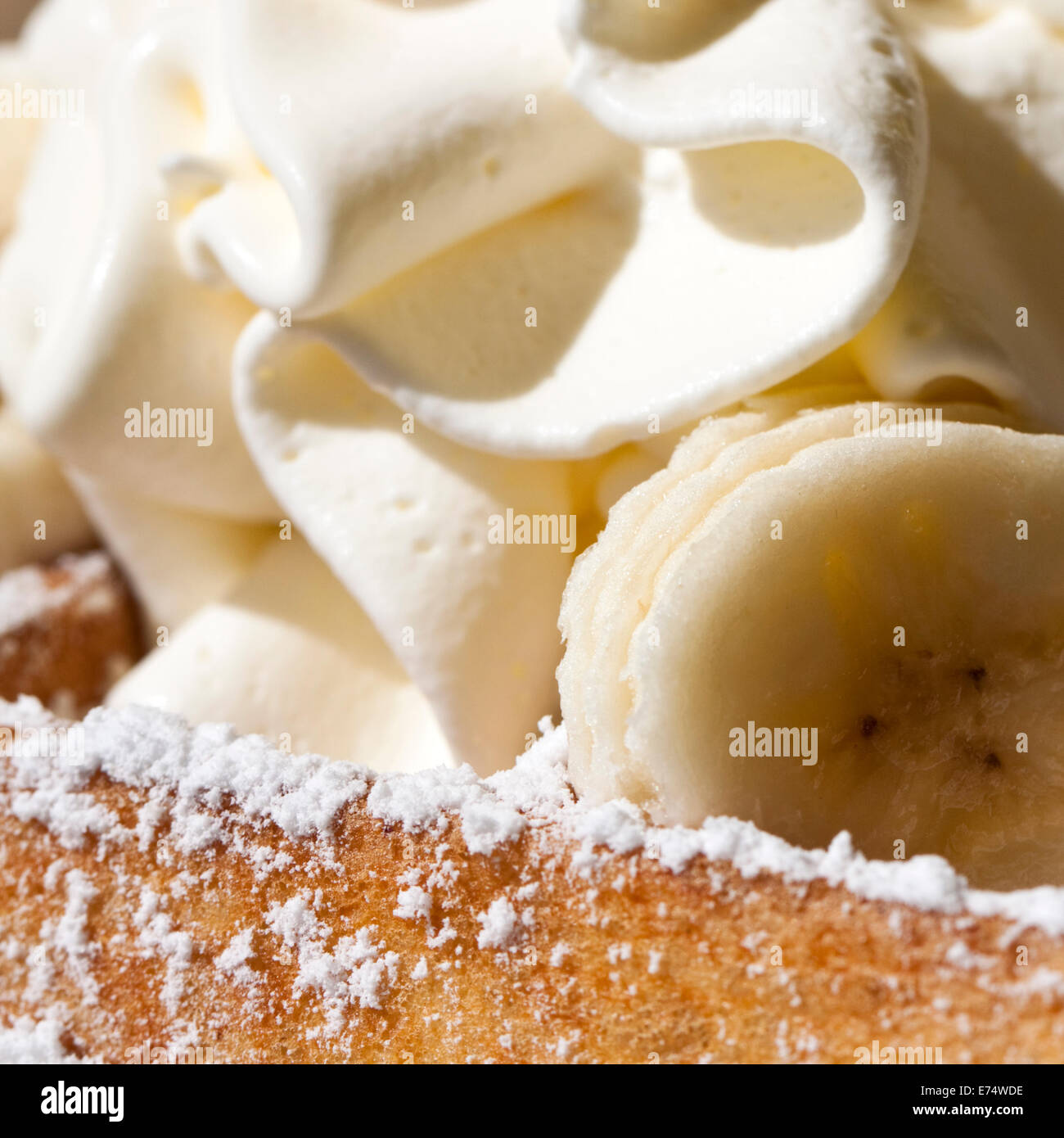 Fresh 'Brussels Waffle' topped with whipped cream, sliced banana and confectioner's sugar, a popular dish in Belgium. Stock Photo
