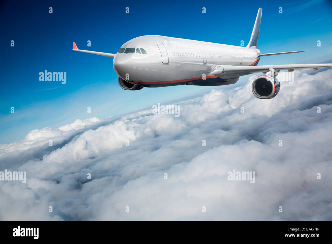 Passenger Airliner flying in the clouds Stock Photo