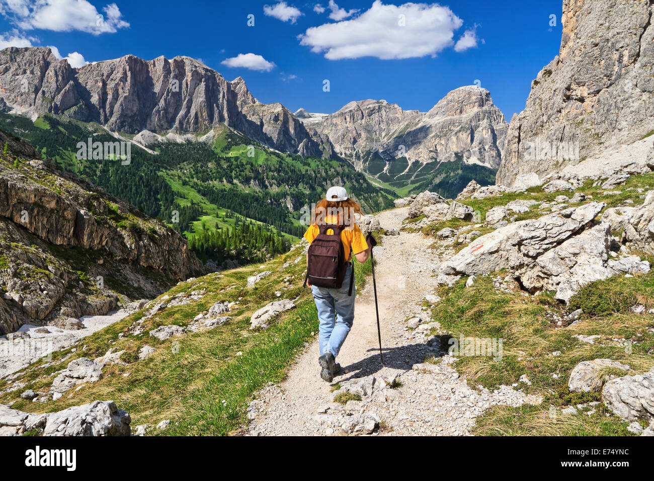 hiker on footpath  in Sella mountain, on background Colfosco and Badia Valley, south Tyrol, Italy Stock Photo