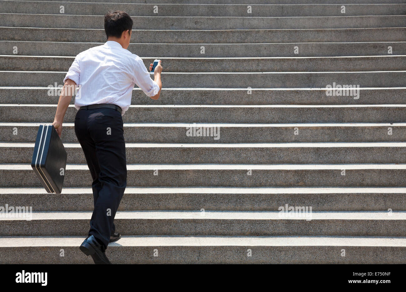 businessman holding mobile and in hurry to run up on stairs Stock Photo ...