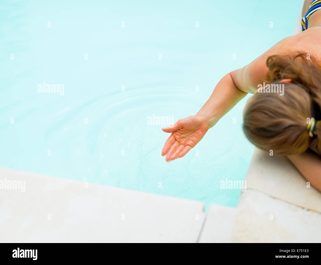 Closeup on young woman playing with water in swimming pool Stock Photo ...