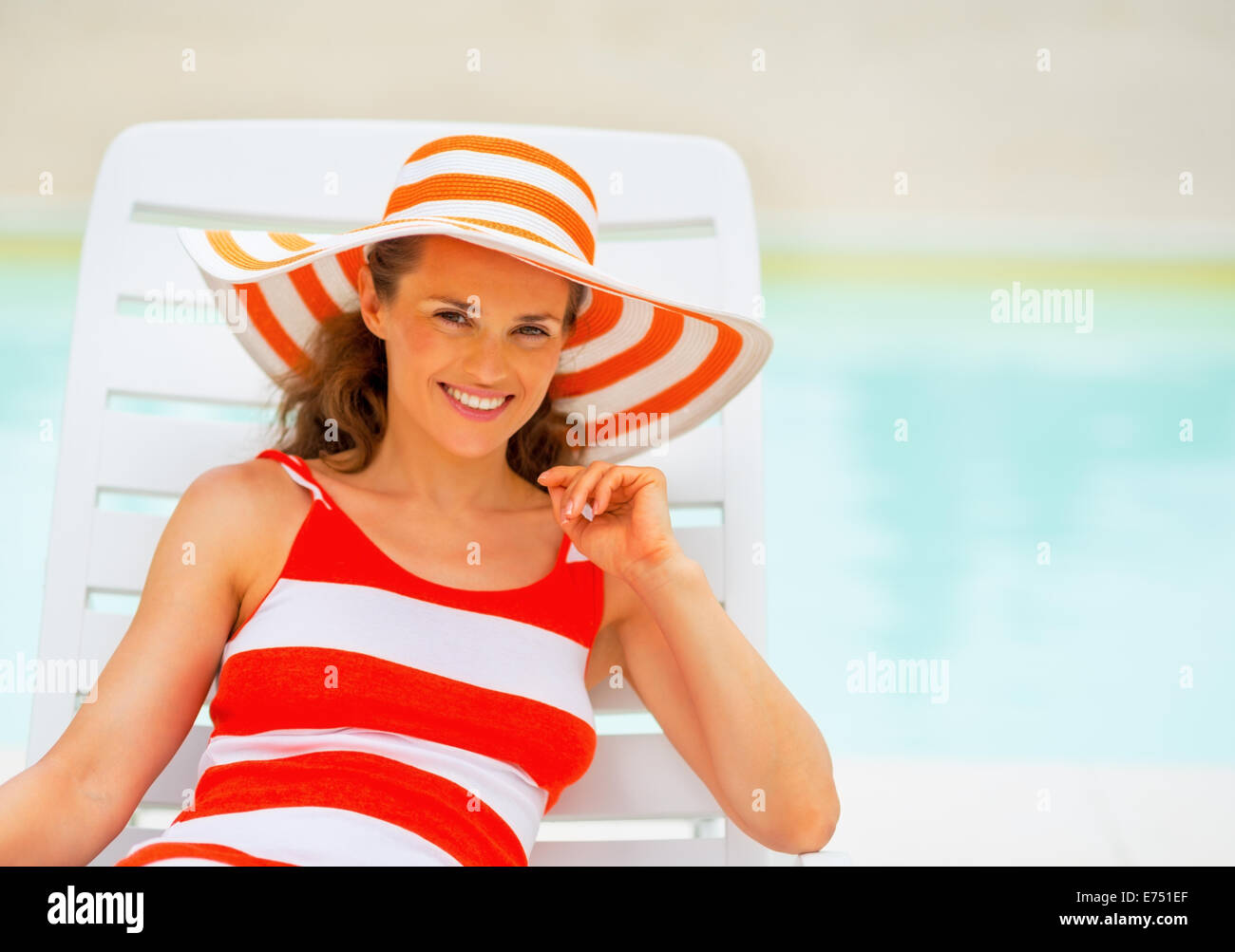 Portrait of happy young woman in hat laying on sunbed Stock Photo - Alamy