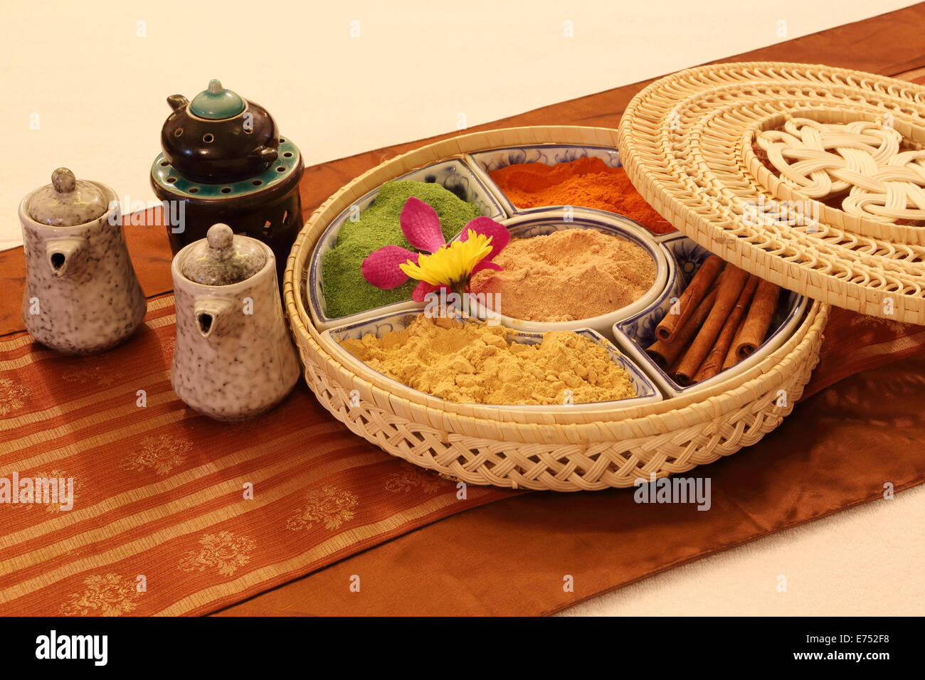 Tea pots and South-East Asian spices in a woven presentation box on silk. Stock Photo