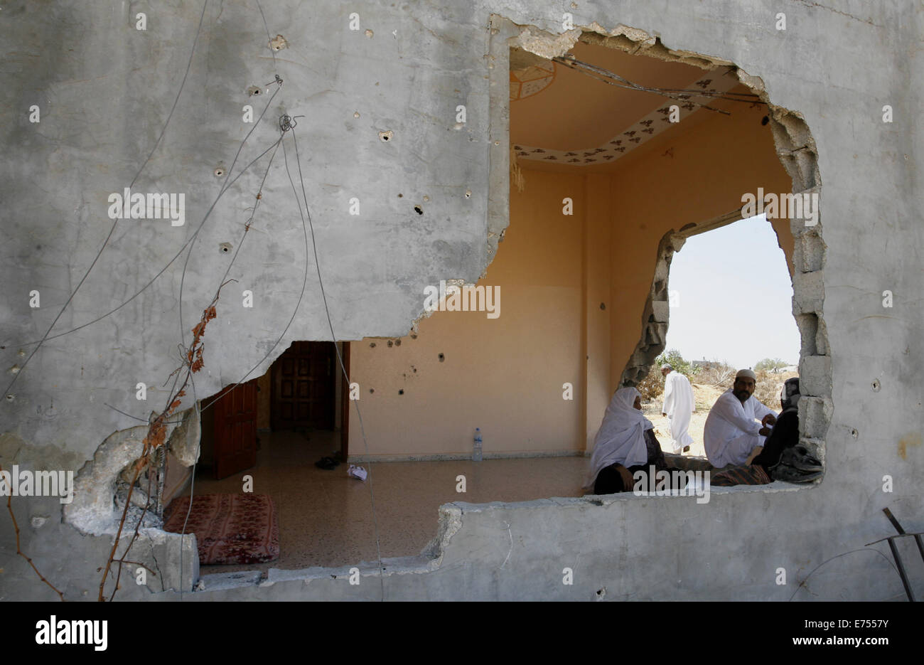 Rafah, Gaza Strip, Palestinian Territory. 7th Sep, 2014. Palestinians sit on the rubble of their house which destroyed during fighting between Hamas militants and Israel in east of Rafah in southern Gaza strip on September 07, 2014. Calm returned to the coastal enclave in a August 26 ceasefire, and Gazans were gradually starting to rebuild their lives after a bloody and destructive 50-day war, the deadliest for years Credit:  Abed Rahim Khatib/APA Images/ZUMA Wire/Alamy Live News Stock Photo