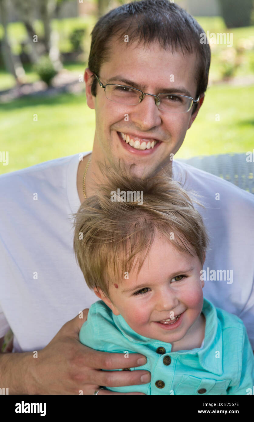 Father and Toddler Son Looking at Camera in Backyard, USA Stock Photo