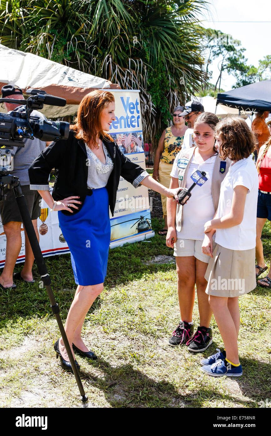 Local TV news woman interviewing two girl scouts in SW Florida Stock Photo