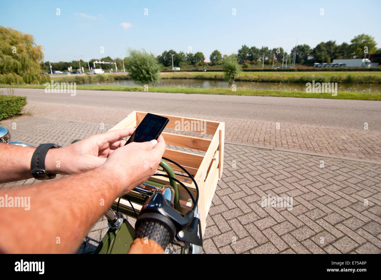Man riding on a bike with a smartphone in his hand Stock Photo