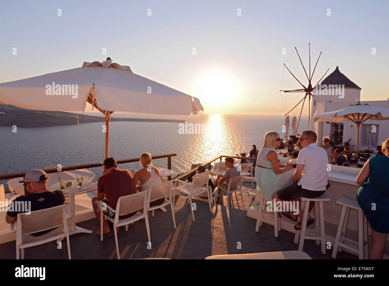 Tourists watching the worldfamous sunset in a bar in Oia , in