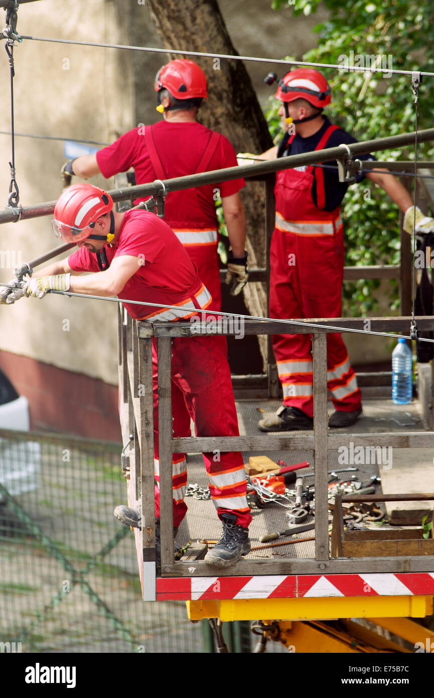 Tram power grid maintenance works in Warsaw, Poland. Workers in truck basket crane. Stock Photo