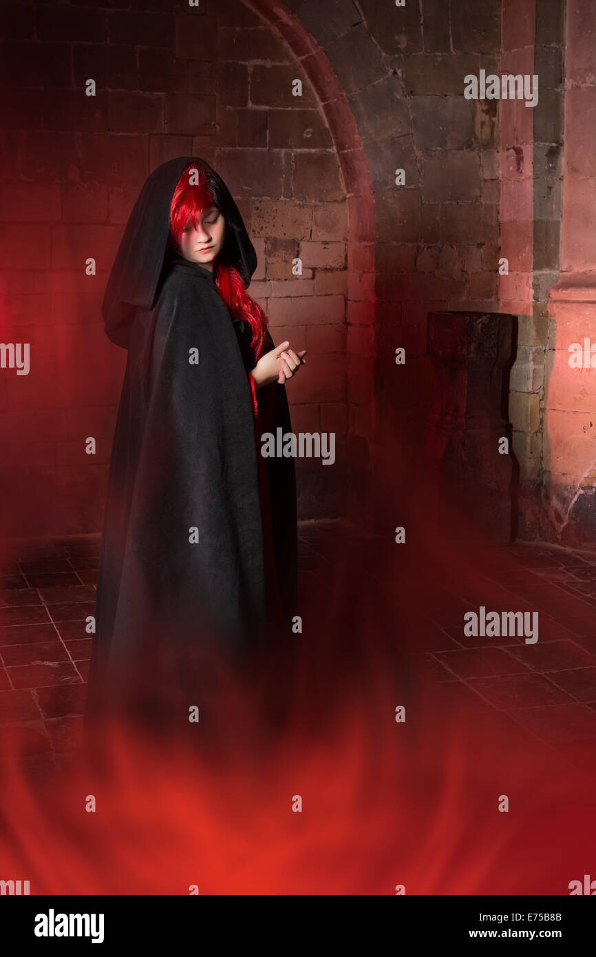 Foggy scene with a beautiful vampire gothic woman in a medieval abbey Stock Photo