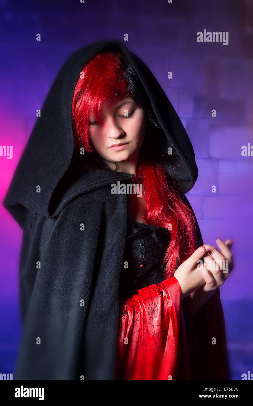 Beautiful young gothic girl in closeup against a colored smoke background Stock Photo