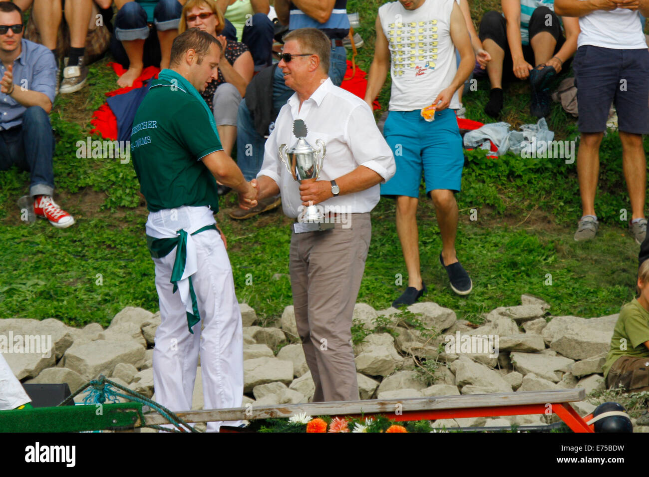 Worms, Germany. 7th September 2014. The Lord Mayor of Worms, Michael Kissel (right), congratulates the winner of the 2014 Fischerstechen (fishermen's joust). Fifteen teams each consisting of 2 rowers and one man fighting with a lance, competed in the 65th anniversary Fischerstechen (Fishermen's Joust) held on the final day of the Backfischfest. Credit:  Michael Debets/Alamy Live News Stock Photo