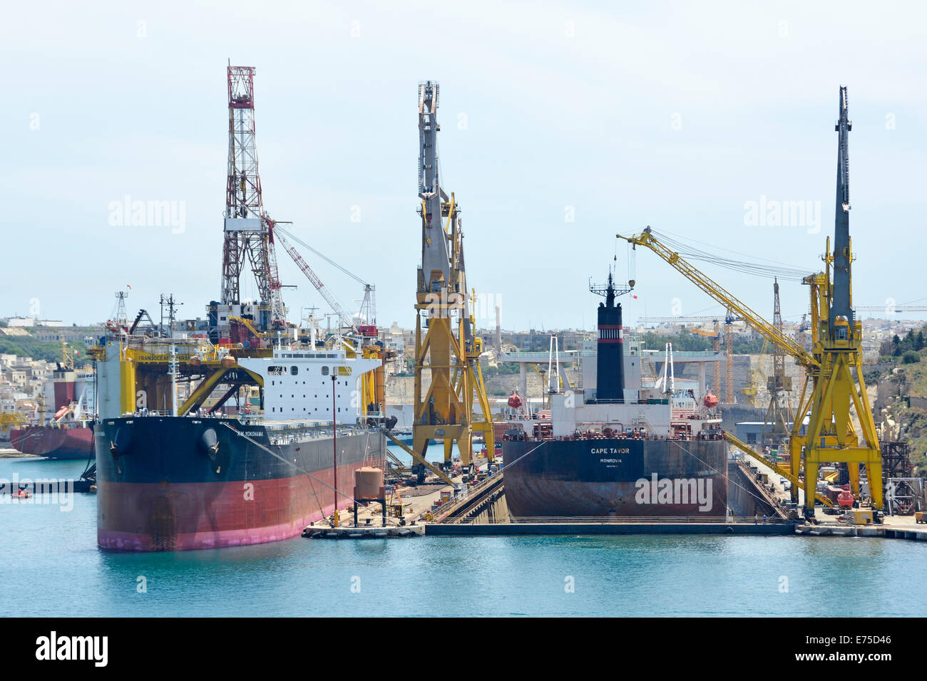 Shipping moored in repair & maintenance yards of the Grand Harbour dockyard Valletta including dry dock & cranes Malta Mediterranean Sea Europe Stock Photo