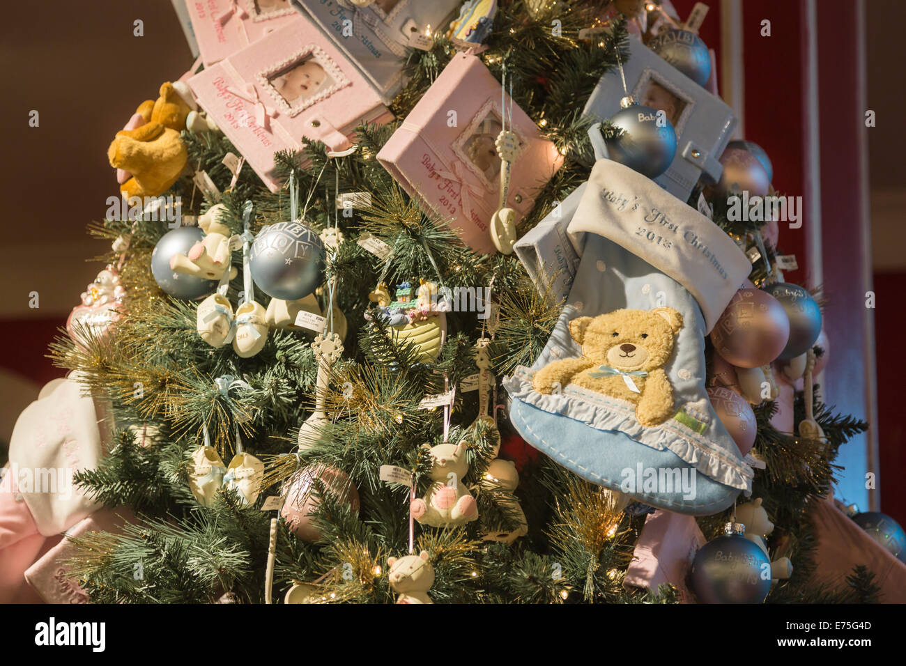 Xmas tree with festive holiday decorations in a New York shop, with blue stocking 'Baby's First Christmas' Stock Photo