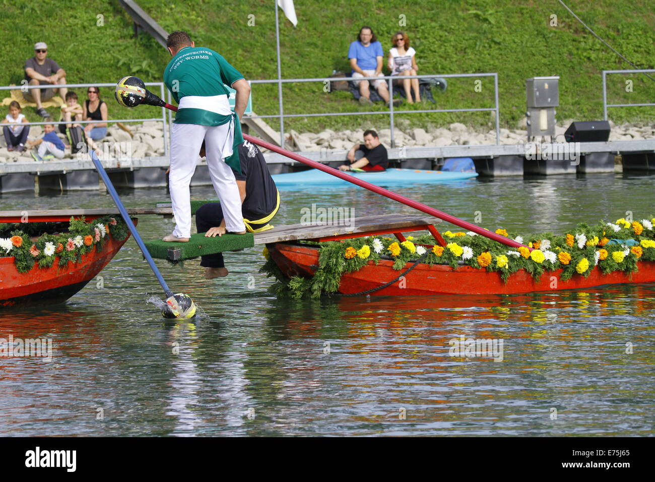The loosing competitor in the final falls onto the winner's boat. Fifteen teams each consisting of 2 rowers and one man fighting with a lance, competed in the 65th anniversary Fischerstechen (Fishermen's Joust) held on the final day of the Backfischfest. © Michael Debets/Pacific Press/Alamy Live News Stock Photo