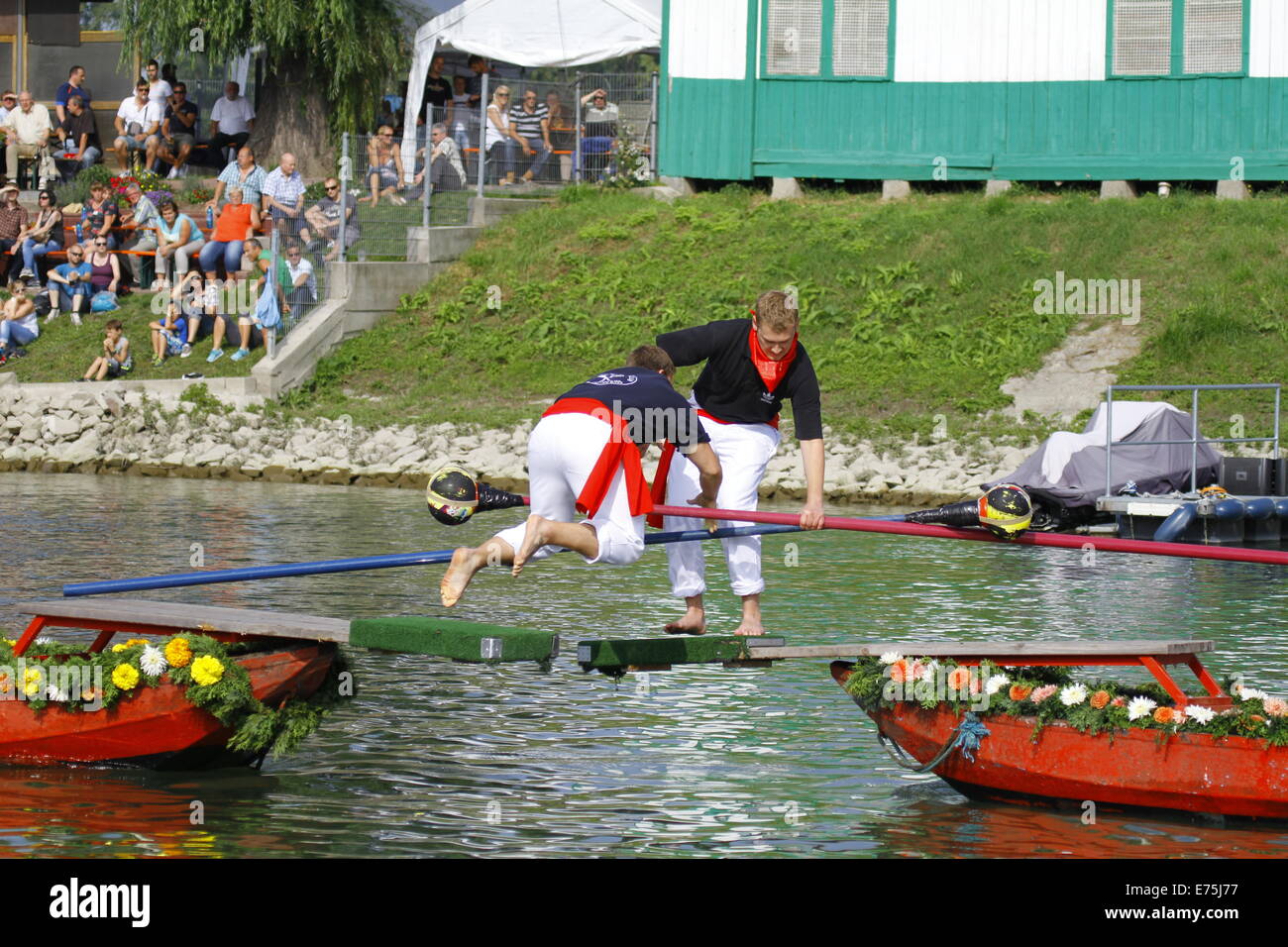 A competitor falls into the river after being pushed by his opponent. Fifteen teams each consisting of 2 rowers and one man fighting with a lance, competed in the 65th anniversary Fischerstechen (Fishermen's Joust) held on the final day of the Backfischfest. © Michael Debets/Pacific Press/Alamy Live News Stock Photo