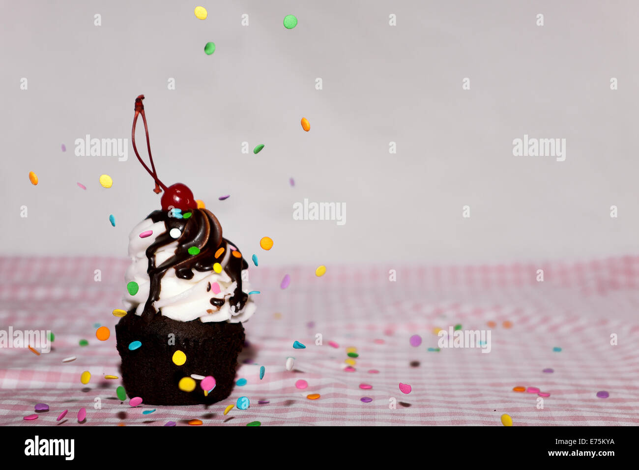 A Holiday Cupcake With Sprinkles Falling On It Stock Photo Alamy