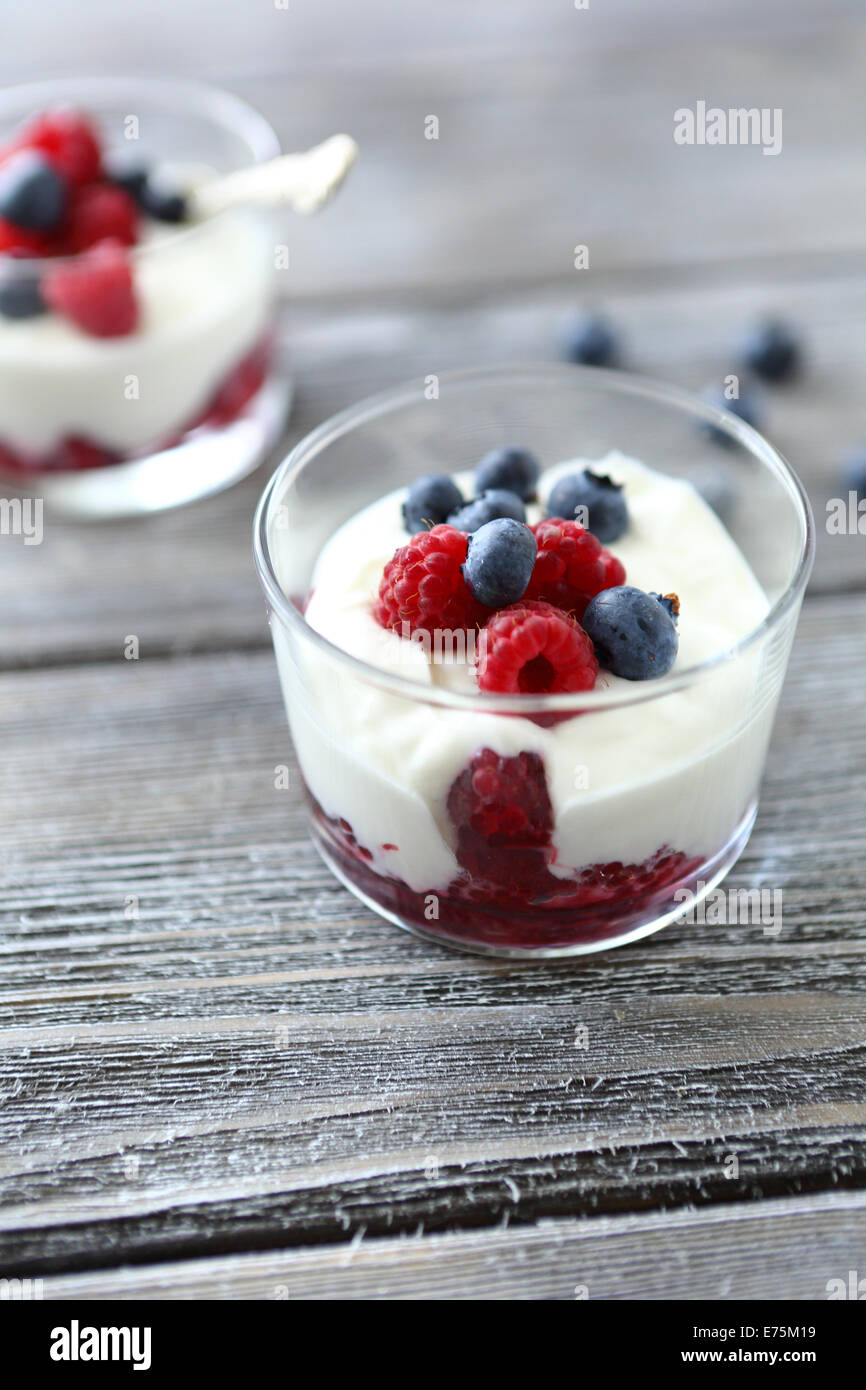 Yogurt with berries in glass jars, fresh dessert Stock Photo