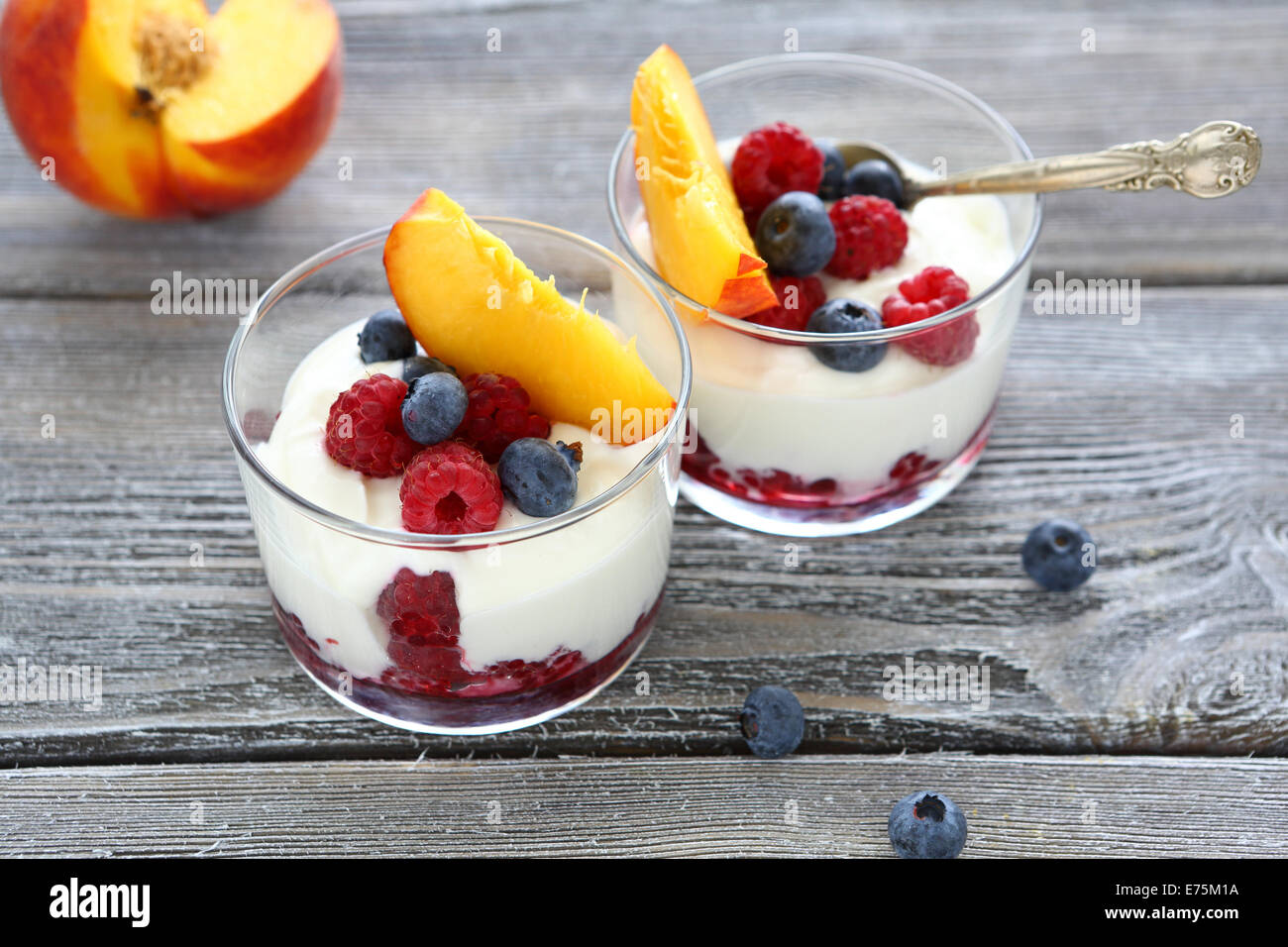 Yogurt with peach slices raspberries and blueberries, tasty dessert Stock Photo