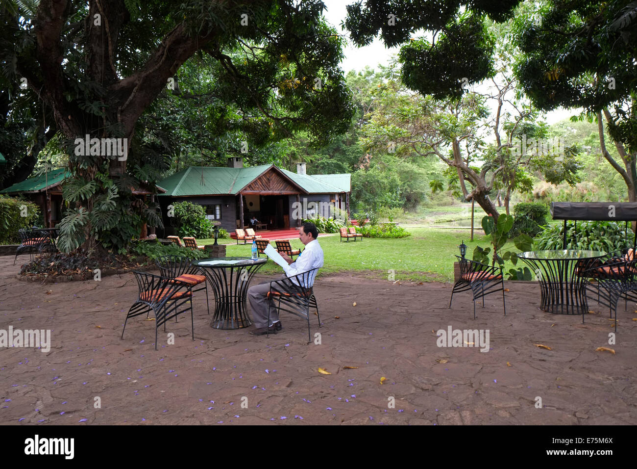 A tourist from India reading newspaper in Mount Meru Game lodge in the town of Arusha northern Tanzania Eastern Africa Stock Photo