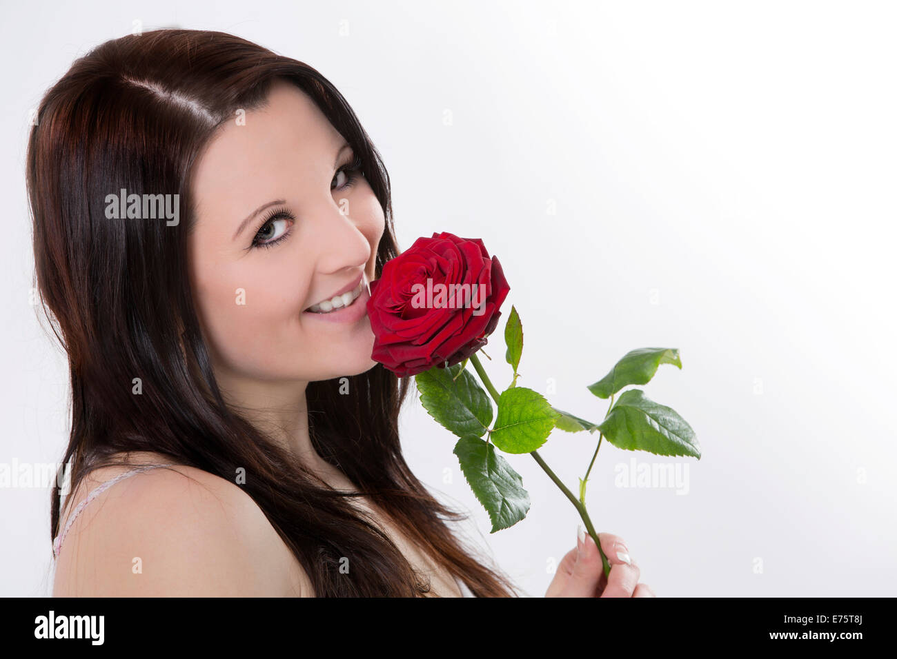 Smiling young woman with a red rose Stock Photo