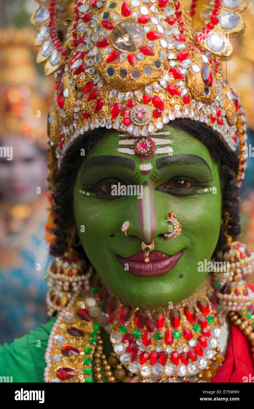 Hindu temple dancer wearing gold jewelry with his face painted green