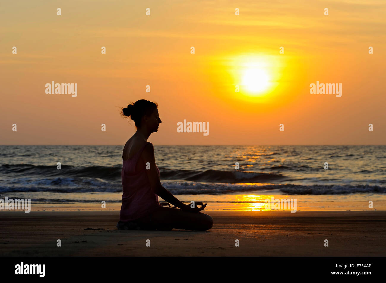 Woman meditating on a beach at sunset, Kerala, India Stock Photo - Alamy