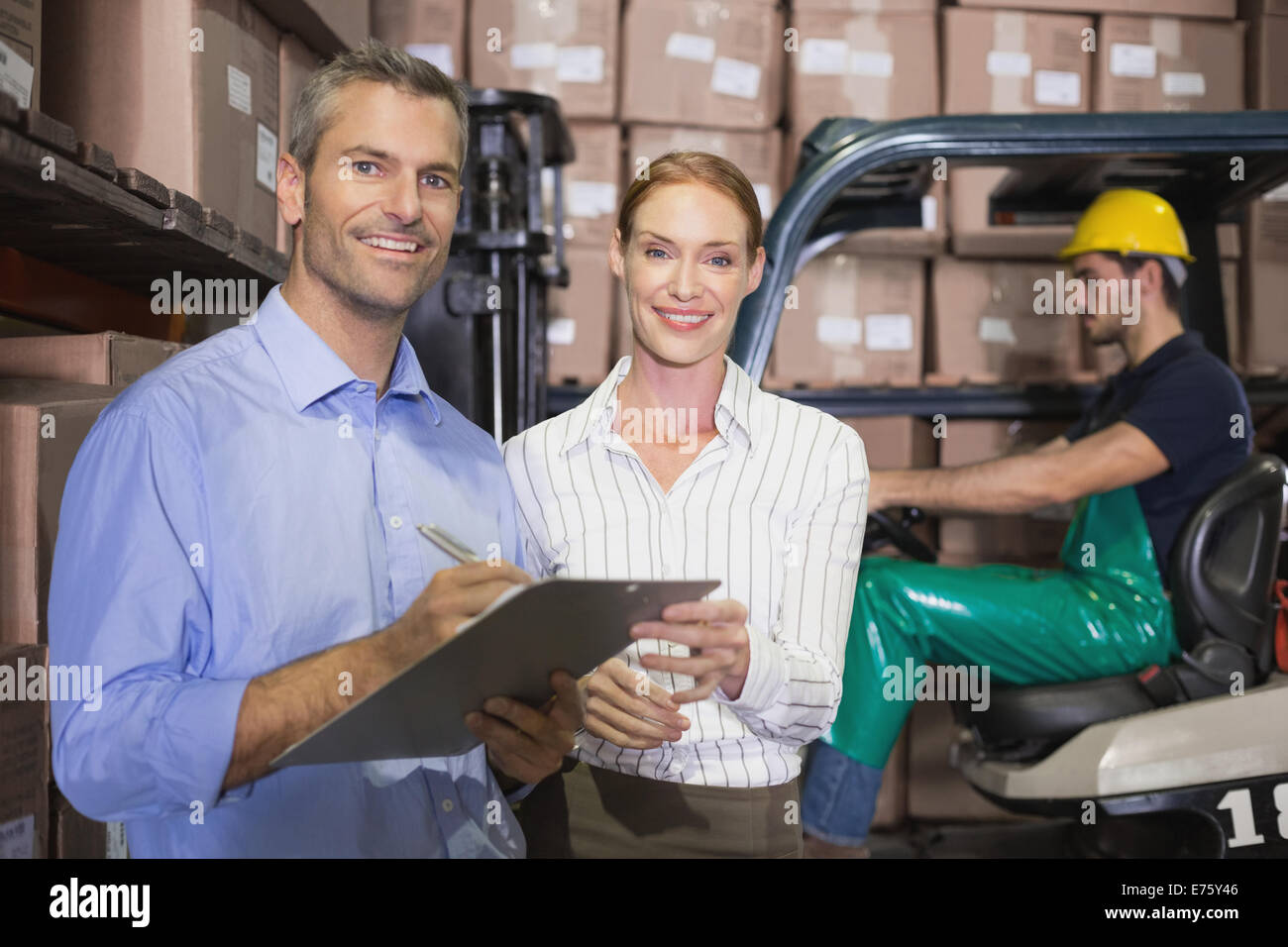 Warehouse team working together with clipboard Stock Photo - Alamy