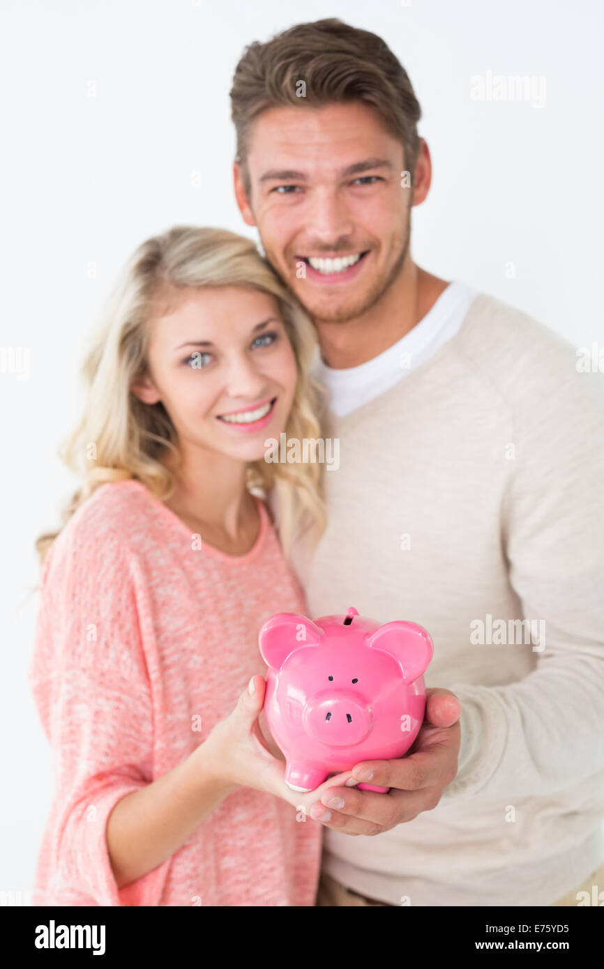 Portrait of attractive young couple holding piggybank Stock Photo - Alamy
