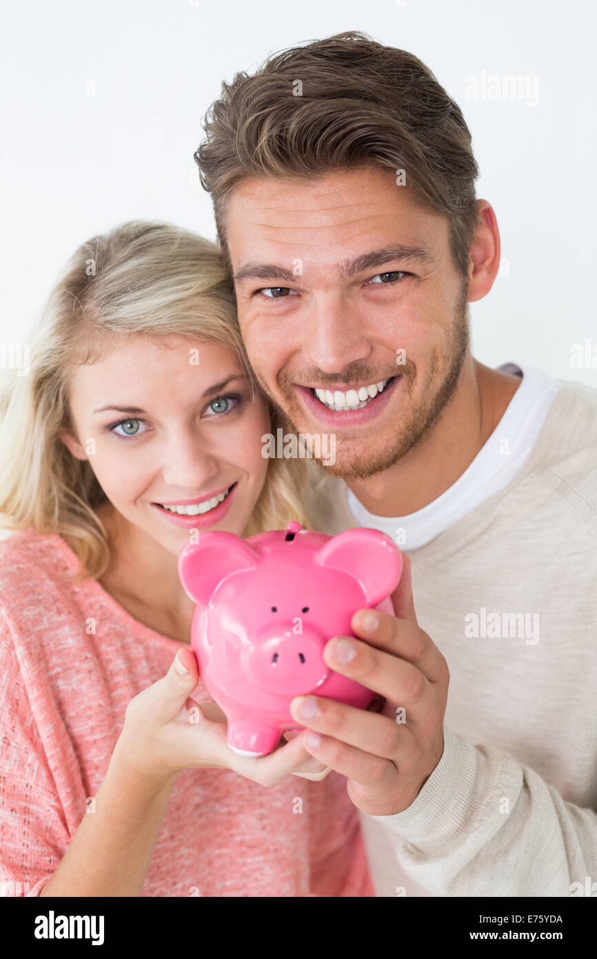 Attractive young couple holding piggybank Stock Photo - Alamy
