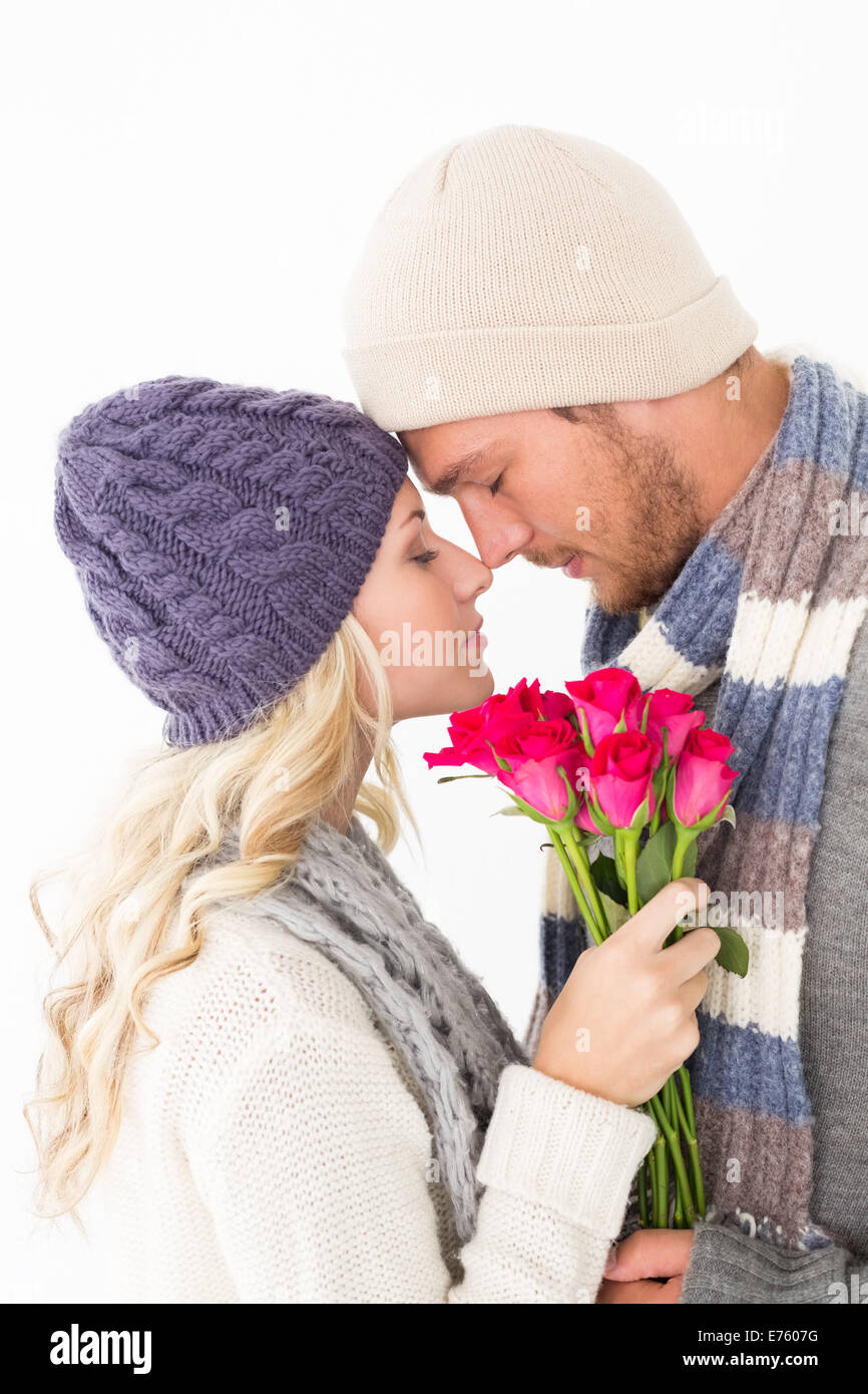 Attractive couple in warm clothing holding flowers Stock Photo