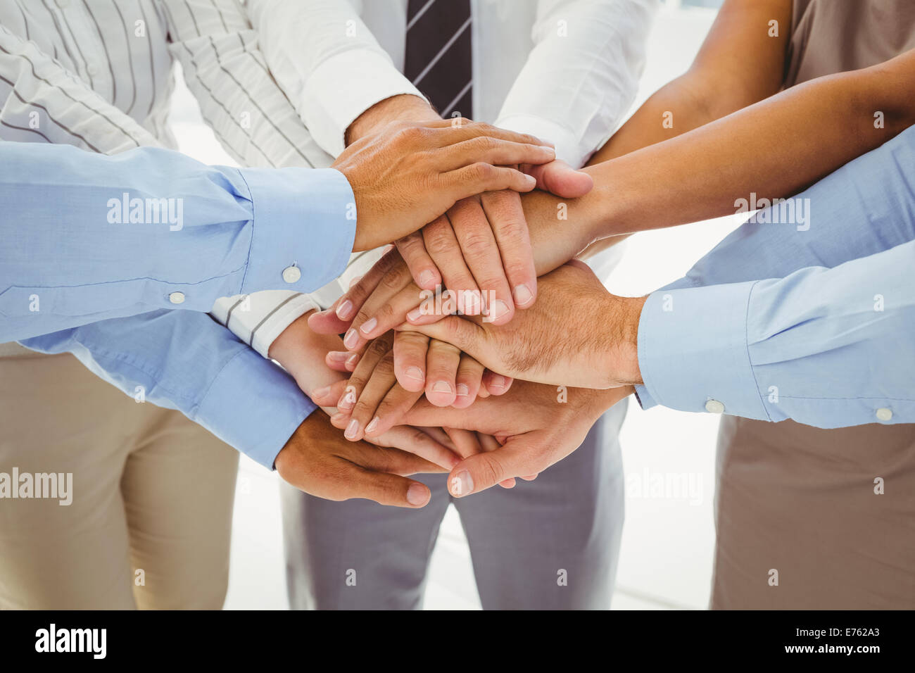 Employees putting hands together Stock Photo