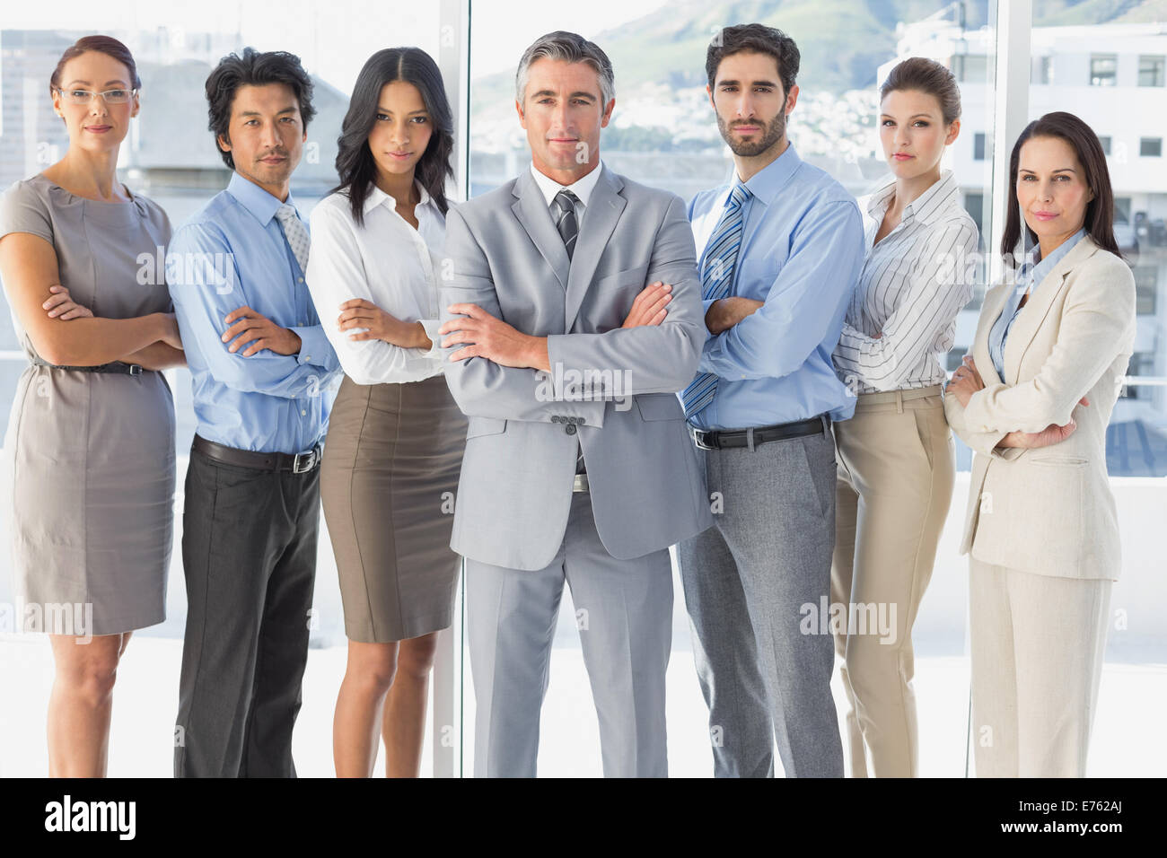 Serious workers standing all together Stock Photo - Alamy