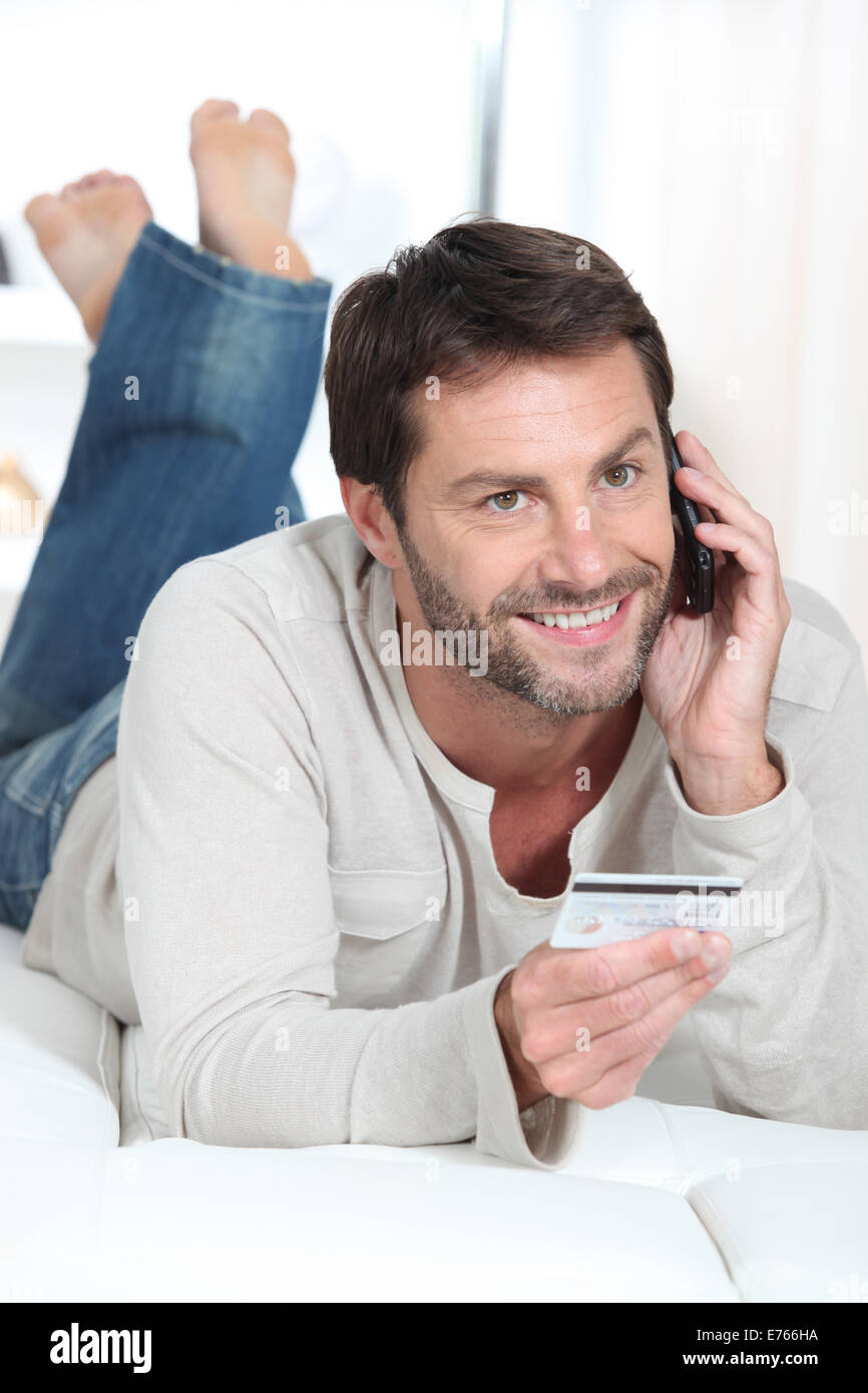 Smiling man using a credit card Stock Photo - Alamy