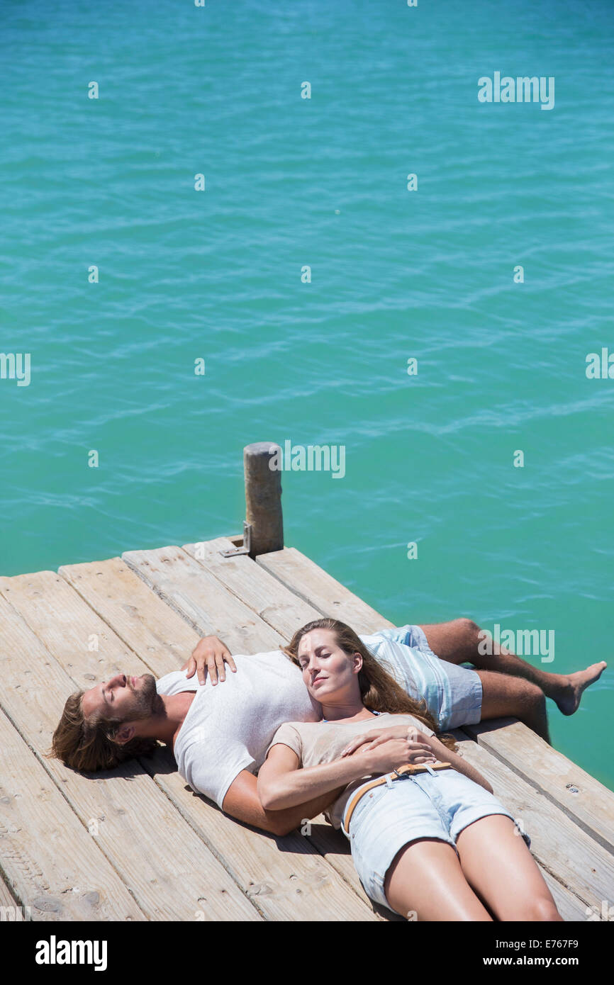 Couple relaxing together on wooden dock Stock Photo